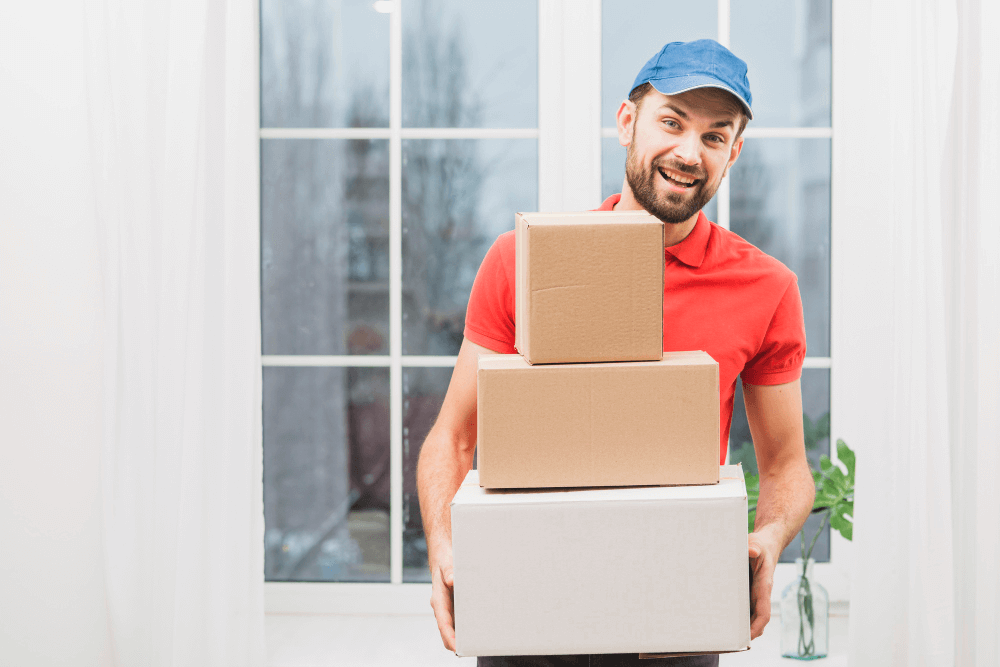 Professional Moving Team Member Holding Cardboard Boxes Indoors